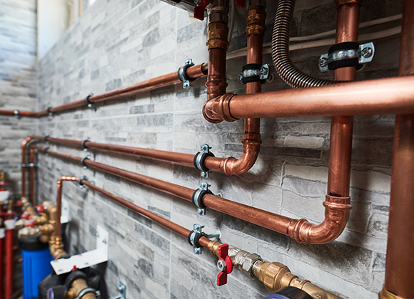 copper plumbing pipes and fittings on a wall with modern design showcasing efficient water systems and potential improvements for 7 home installations