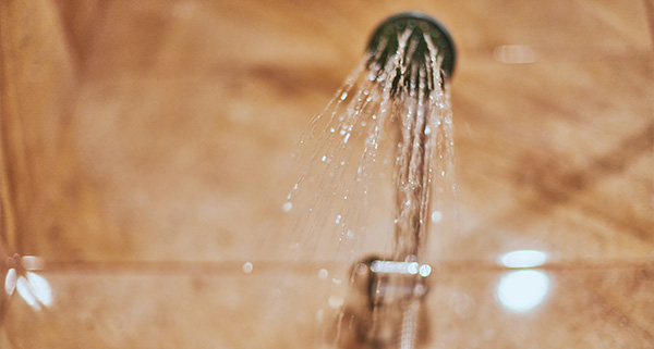 water flowing from a showerhead in a bathroom with a modern design featuring 13 droplets sparkling in the light